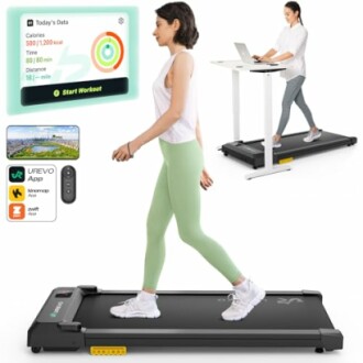 Woman walking on a treadmill with a desk setup and app display.