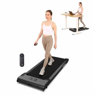 Woman using a walking pad under a desk while working.